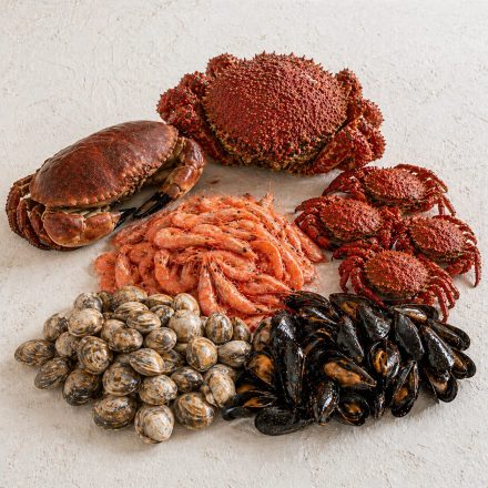 Caja de envío abierta con la mariscada Vigo en su interior, protegida para garantizar que el producto llegue fresco al cliente.