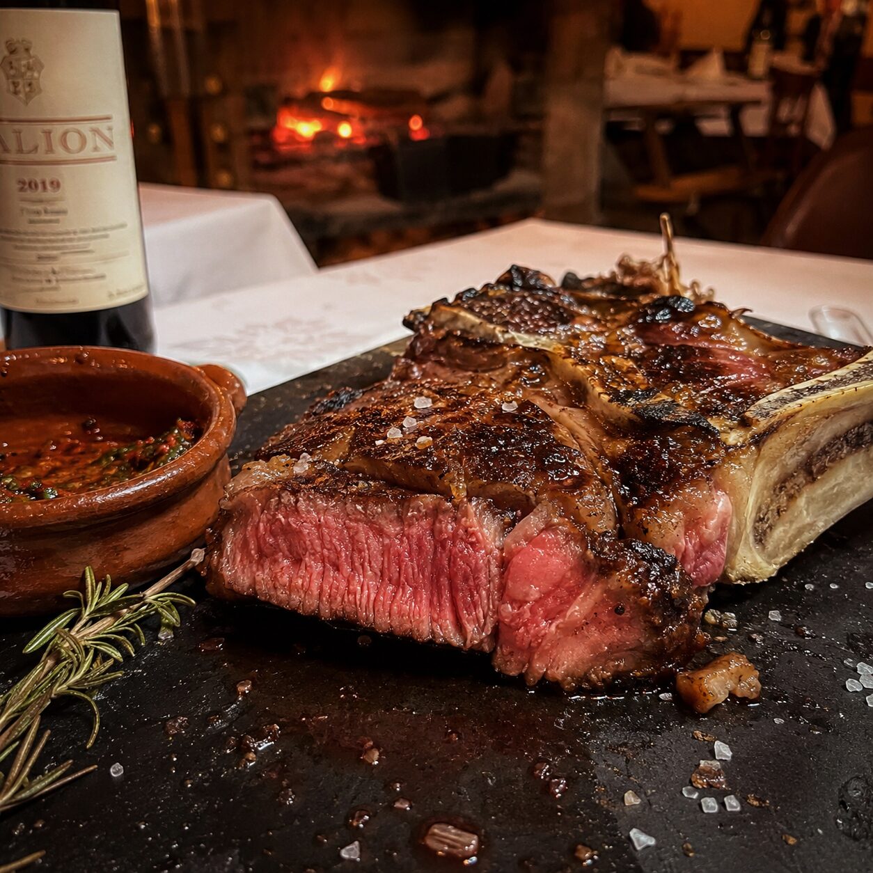 Chuletón de vaca Rubia Gallega Halal perfectamente cocinado al punto, cortado en tiras y servido en un plato elegante.